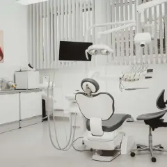 Nowoczesny gabinet stomatologiczny z fotelem, unitem i obrazem ust.