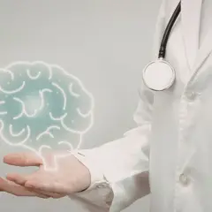 Lekarz w białej kitle z latarką i stetoskopem prezentuje symboliczny mózg, sugerując badanie neurologiczne.