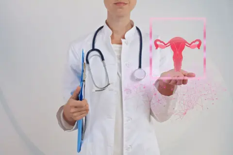 Lekarka prezentuje grafikę narządów rodnych, symbolizującą problemy takie jak krwawienie z pochwy.
