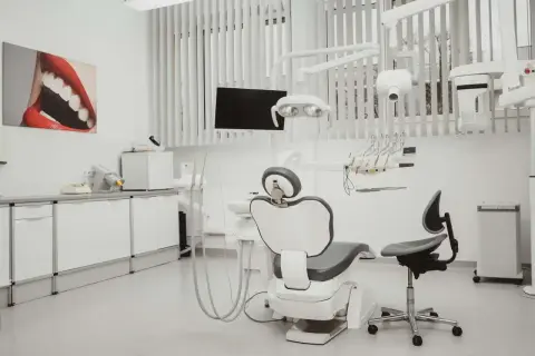Nowoczesny gabinet stomatologiczny z fotelem, unitem i obrazem ust.
