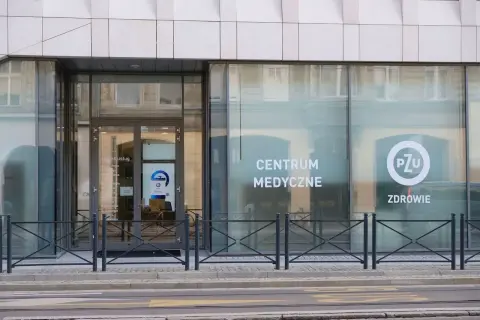 Elegancki budynek z dużymi oknami, na których widnieje napis "CENTRUM MEDYCZNE" i logo PZU.