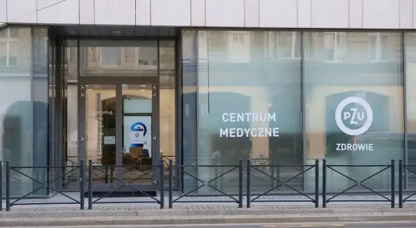 Elegancki budynek z dużymi oknami, na których widnieje napis "CENTRUM MEDYCZNE" i logo PZU.