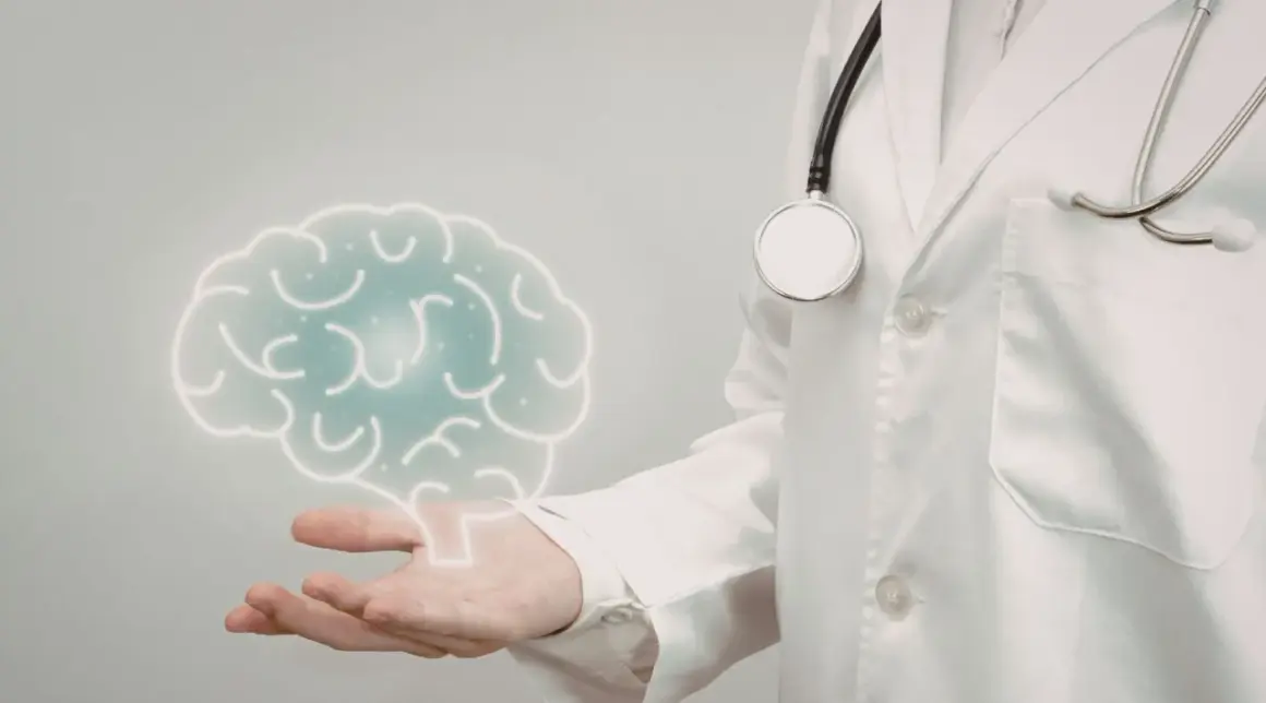 Lekarz w białej kitle z latarką i stetoskopem prezentuje symboliczny mózg, sugerując badanie neurologiczne.
