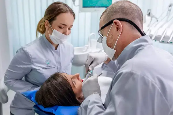 Dentysta leczy zęby pacjentki. Czy próchnica jest zaraźliwa? Warto zapytać specjalistę.